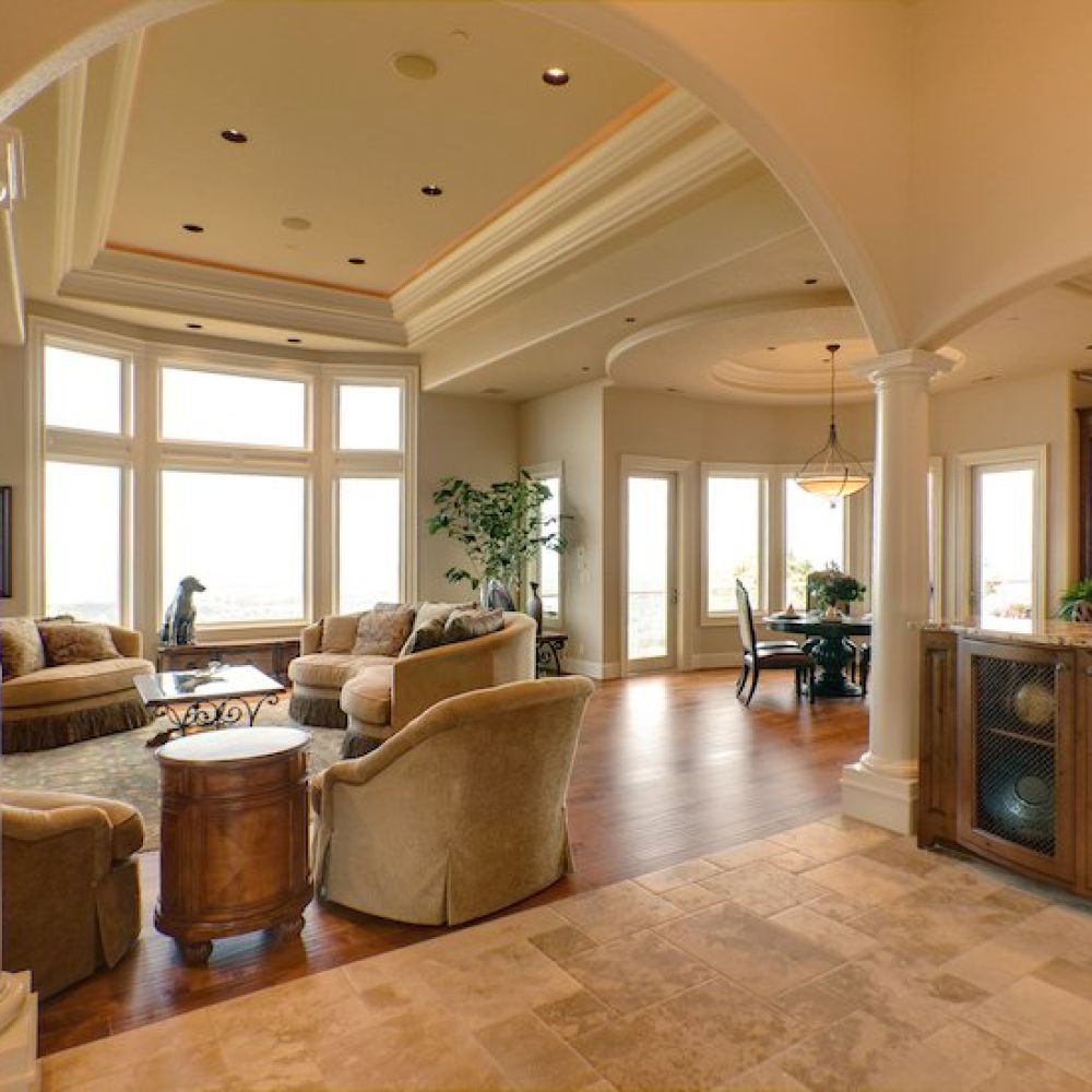 <span class="uk-h4">Zoom out of a living room with multiple couches and in-ceiling speakers. There’s marble countertops off to the side.</span>