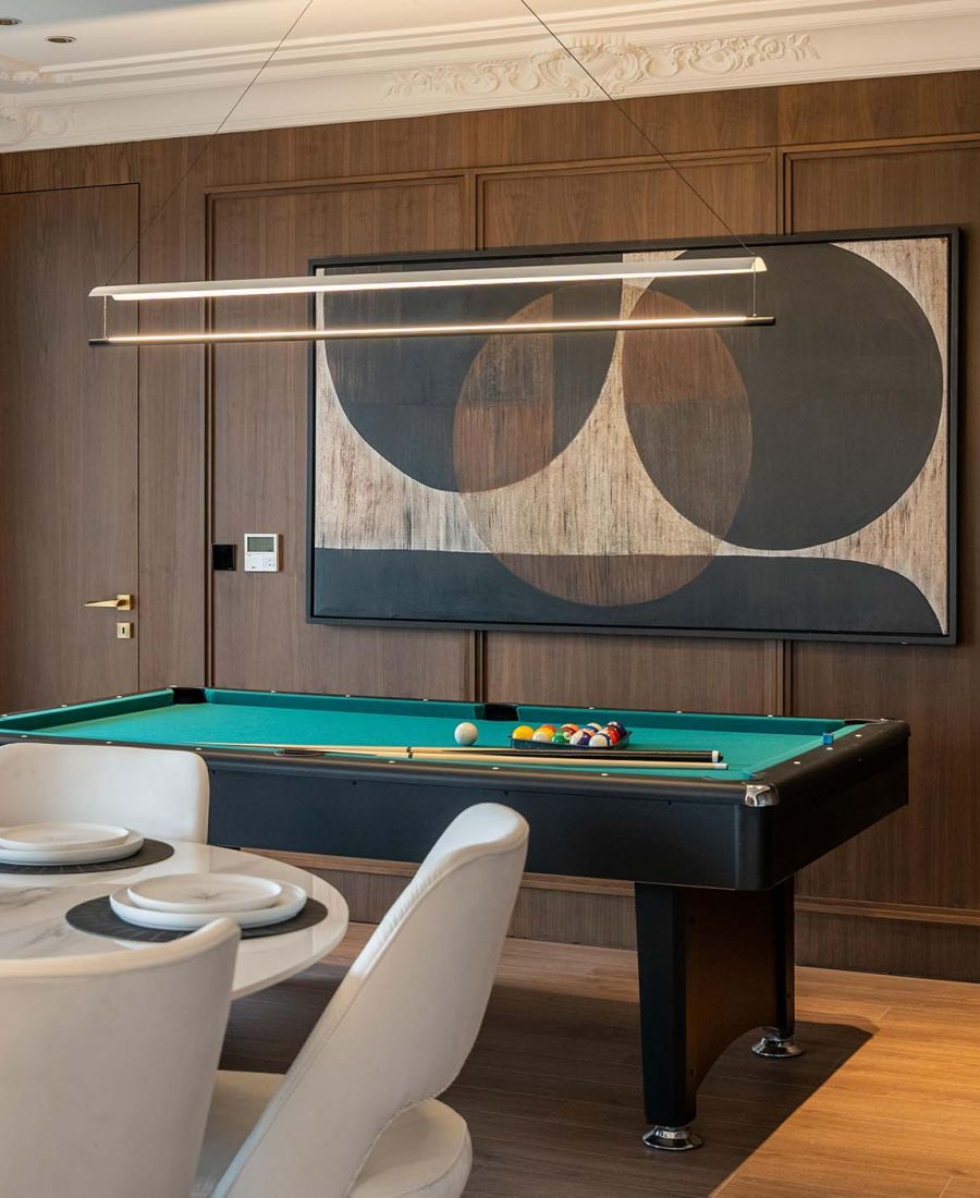 game room with modern light fixtures and wooden paneled walls