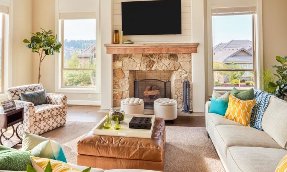 <span class="uk-h4">A family room living area with seating and a mounted TV above a fireplace between two windows.</span>
