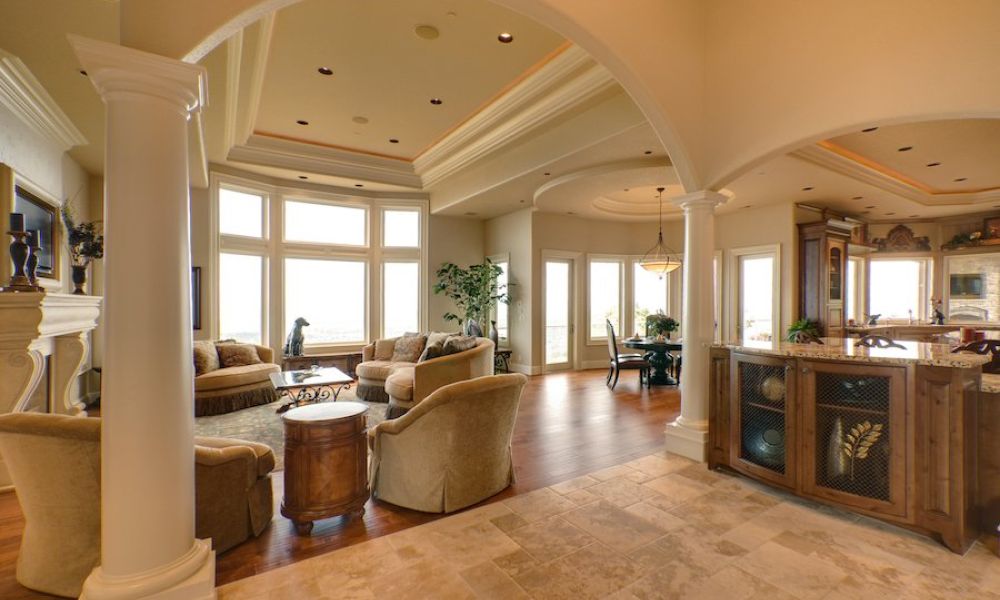 <span class="uk-h4">Zoom out of a living room with multiple couches and in-ceiling speakers. There’s marble countertops off to the side.</span>